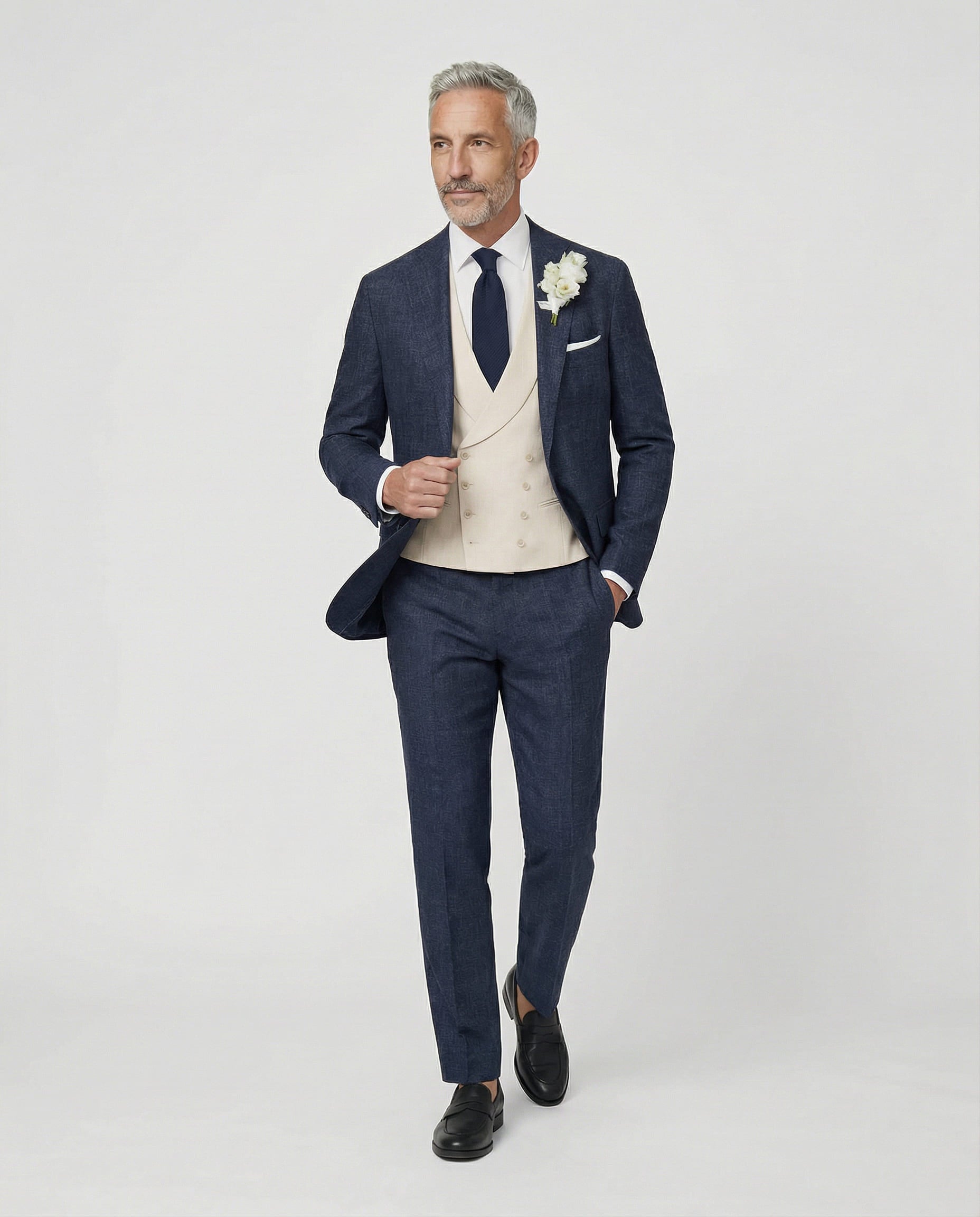 Mann im dunkelblauen Anzug mit beiger Weste Hand am Sakko