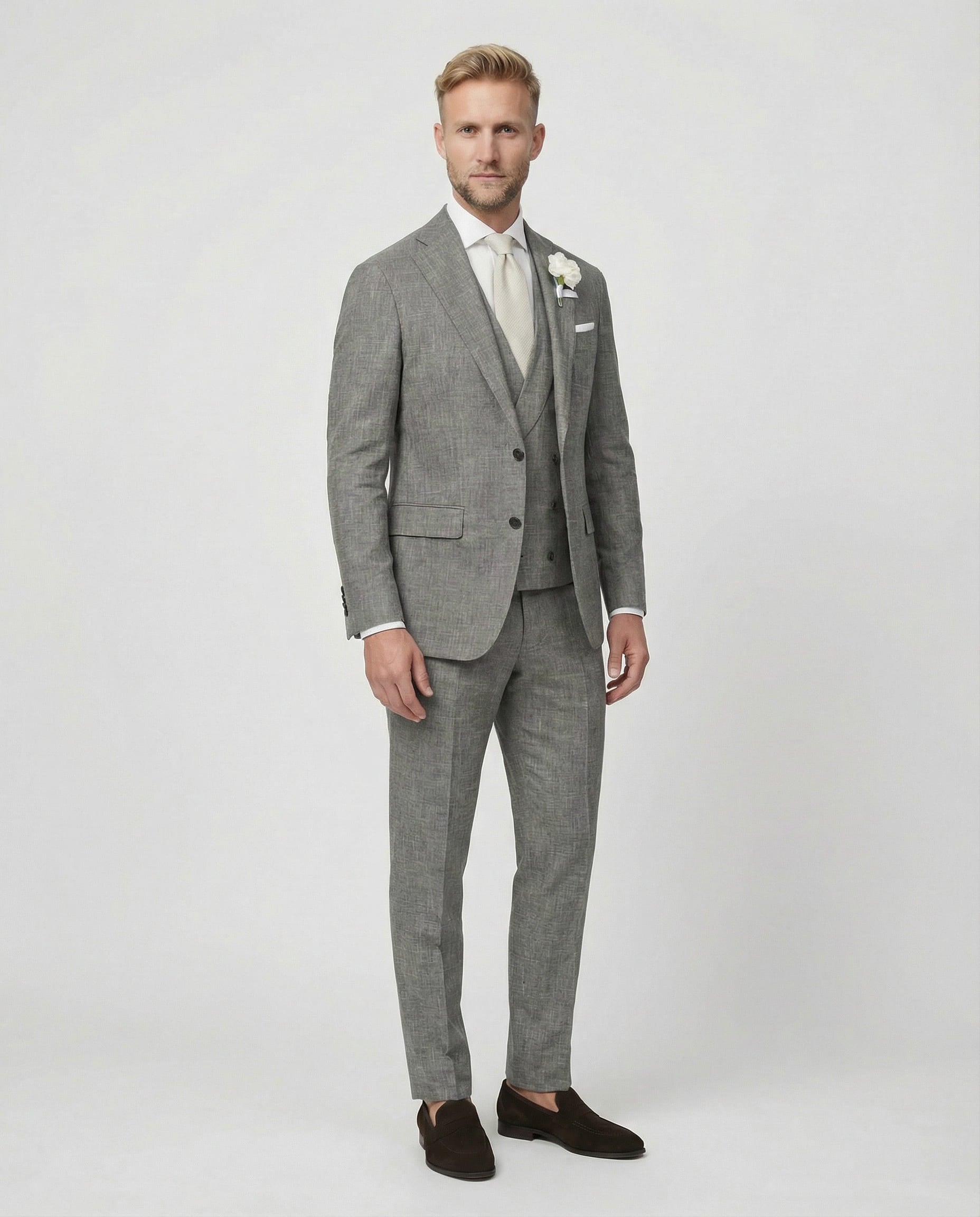 Mann im grauen Anzug mit Weste stehend seitlich fotografiert
