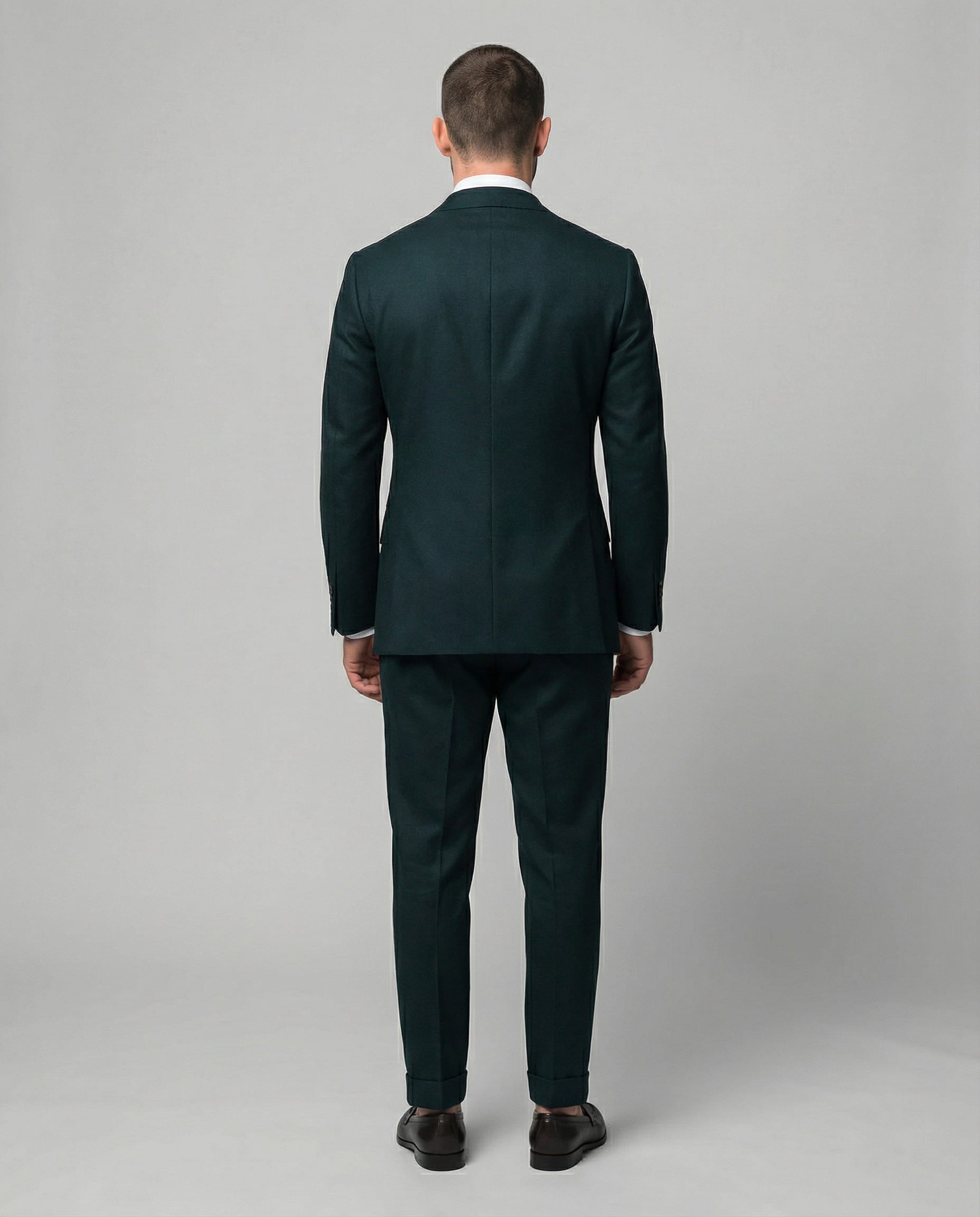 Mann im dunkelgrünen Anzug von hinten fotografiert