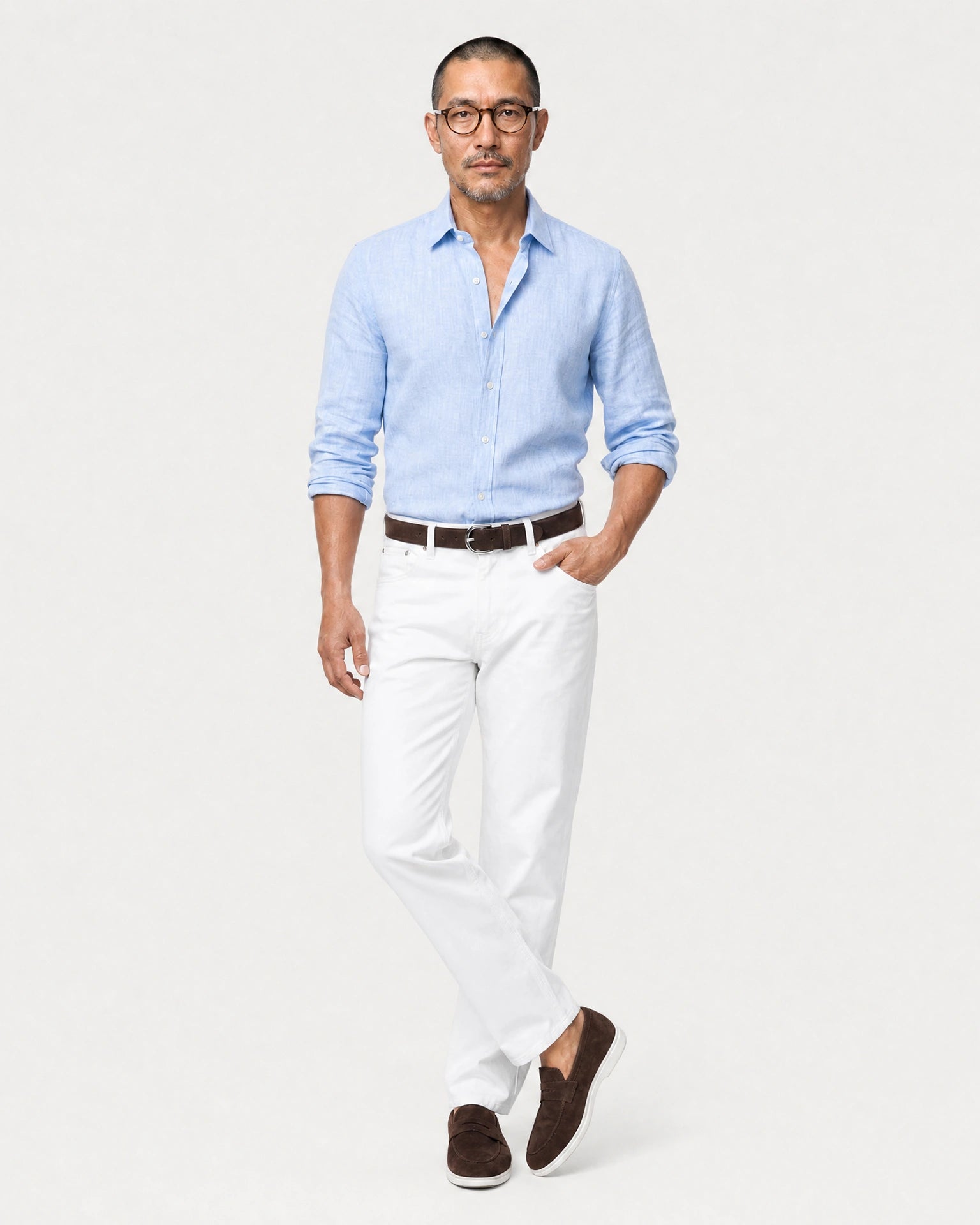 Hellblaues Leinen Langarmhemd Herren in Laufpose, weiße Jeans mit braunem Gürtel und braunen Suede-Loafern