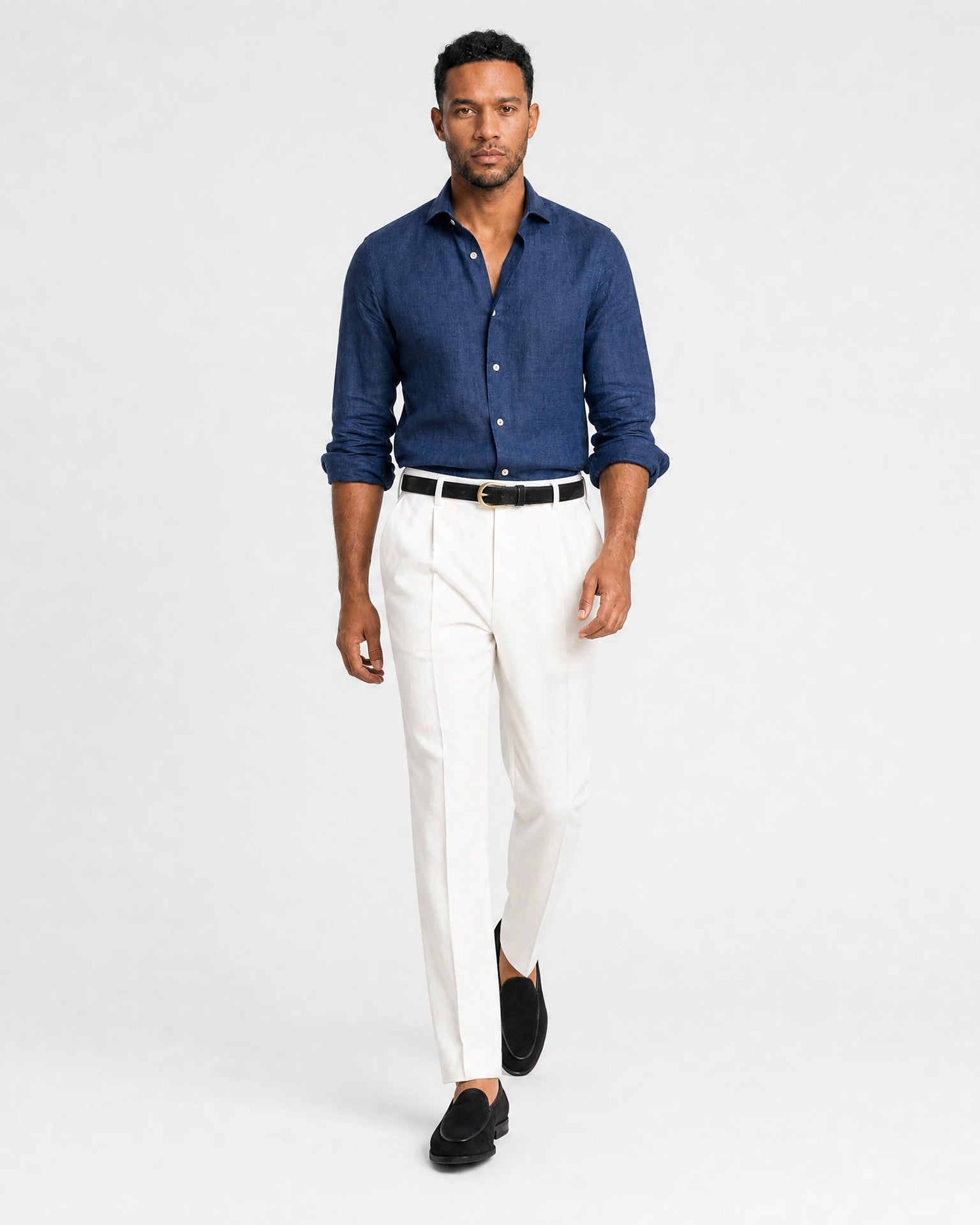 Navy Leinen Maßhemd Herren in Laufpose, weiße Bundfaltenhose mit schwarzem Gürtel und schwarzen Suede-Loafern