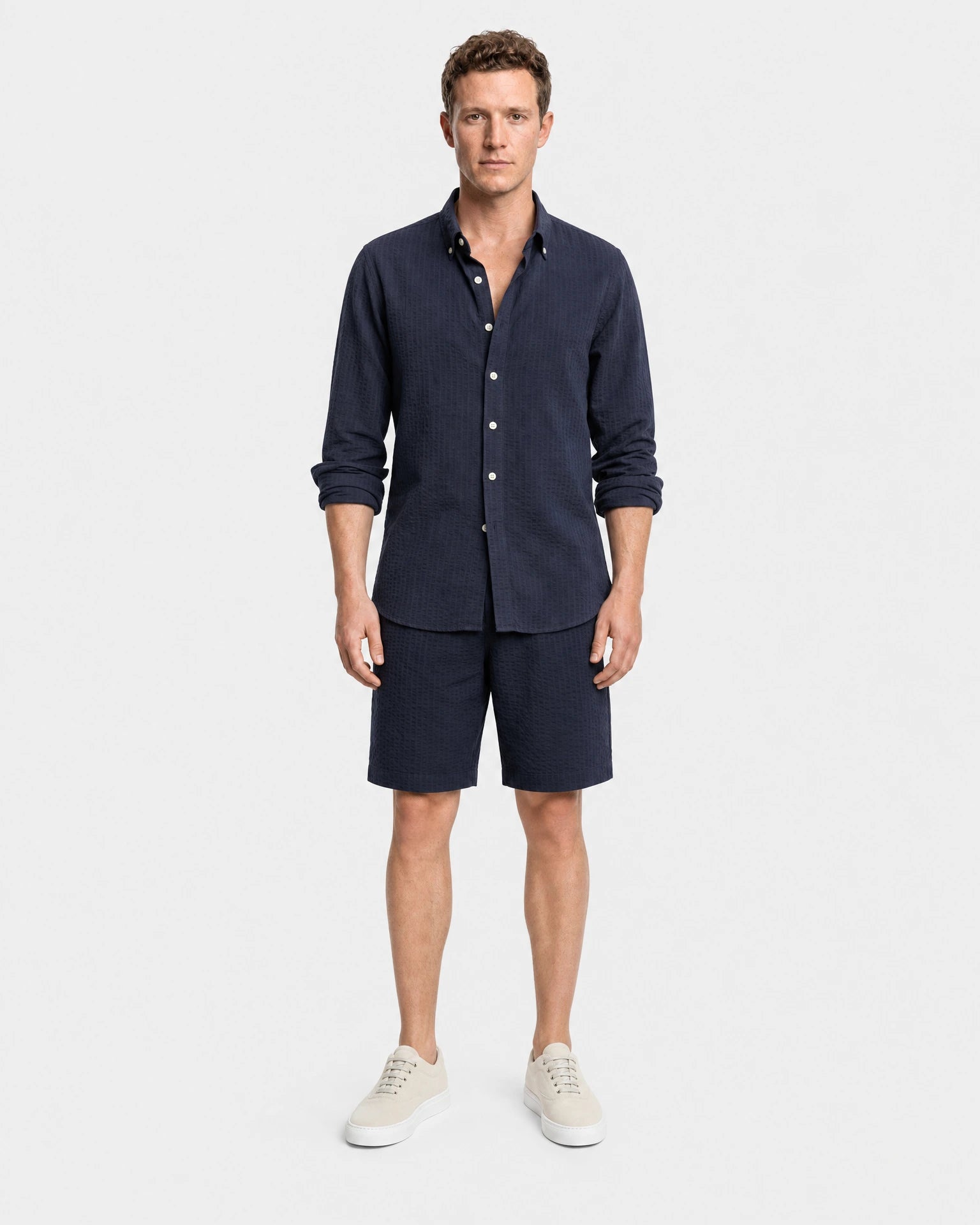 Navy Seersucker Hemd Herren Ganzkörper frontal, kombiniert mit navy Seersucker-Shorts und beigen Sneakern als komplettes Sommer-Set