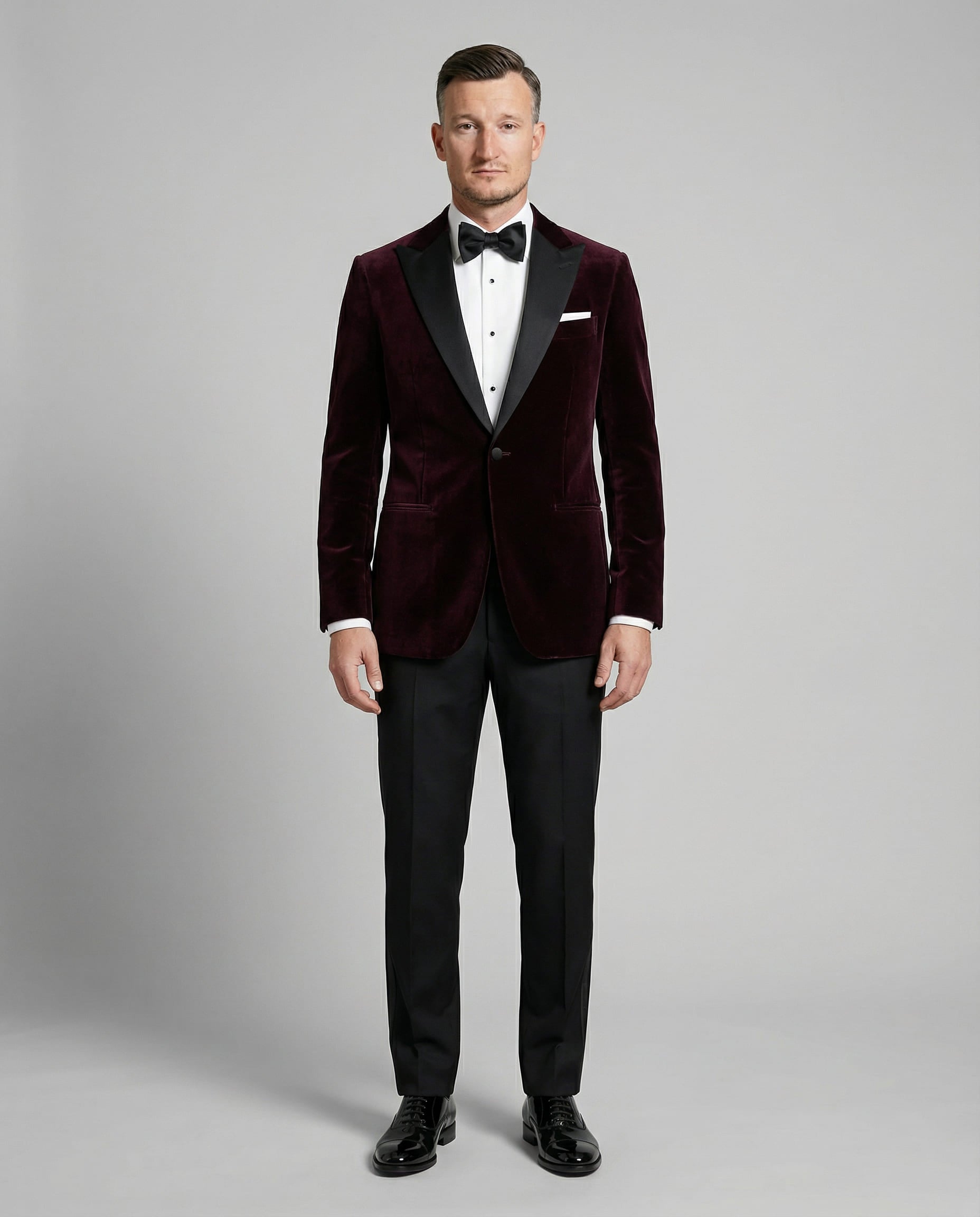Mann im bordeauxfarbenen Samtsakko mit schwarzer Hose von vorne abgebildet