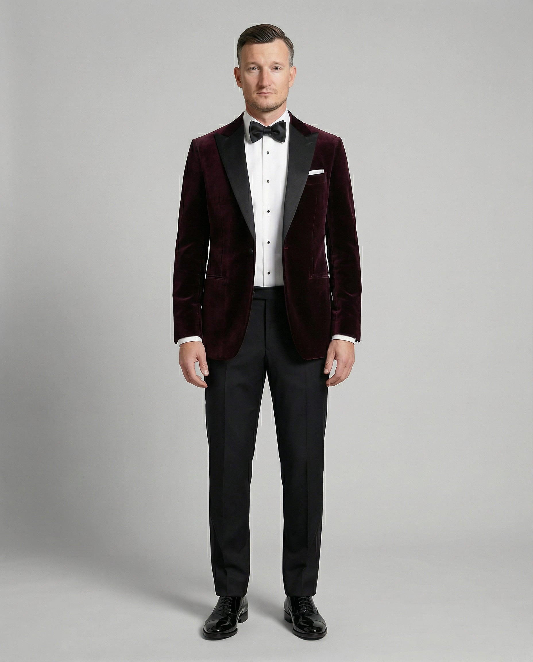 Mann im bordeauxfarbenen Samtsakko mit schwarzer Hose von vorne mit offenem Sakko