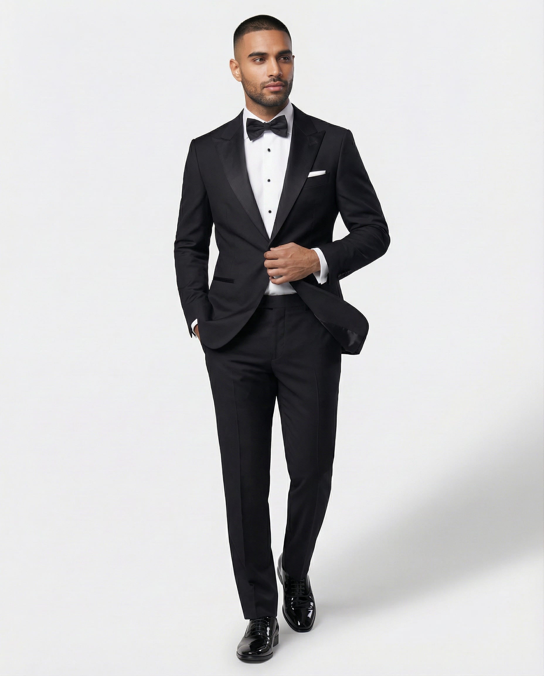 Mann im schwarzen Smoking in Bewegung mit Hand am Knopf von vorne gezeigt