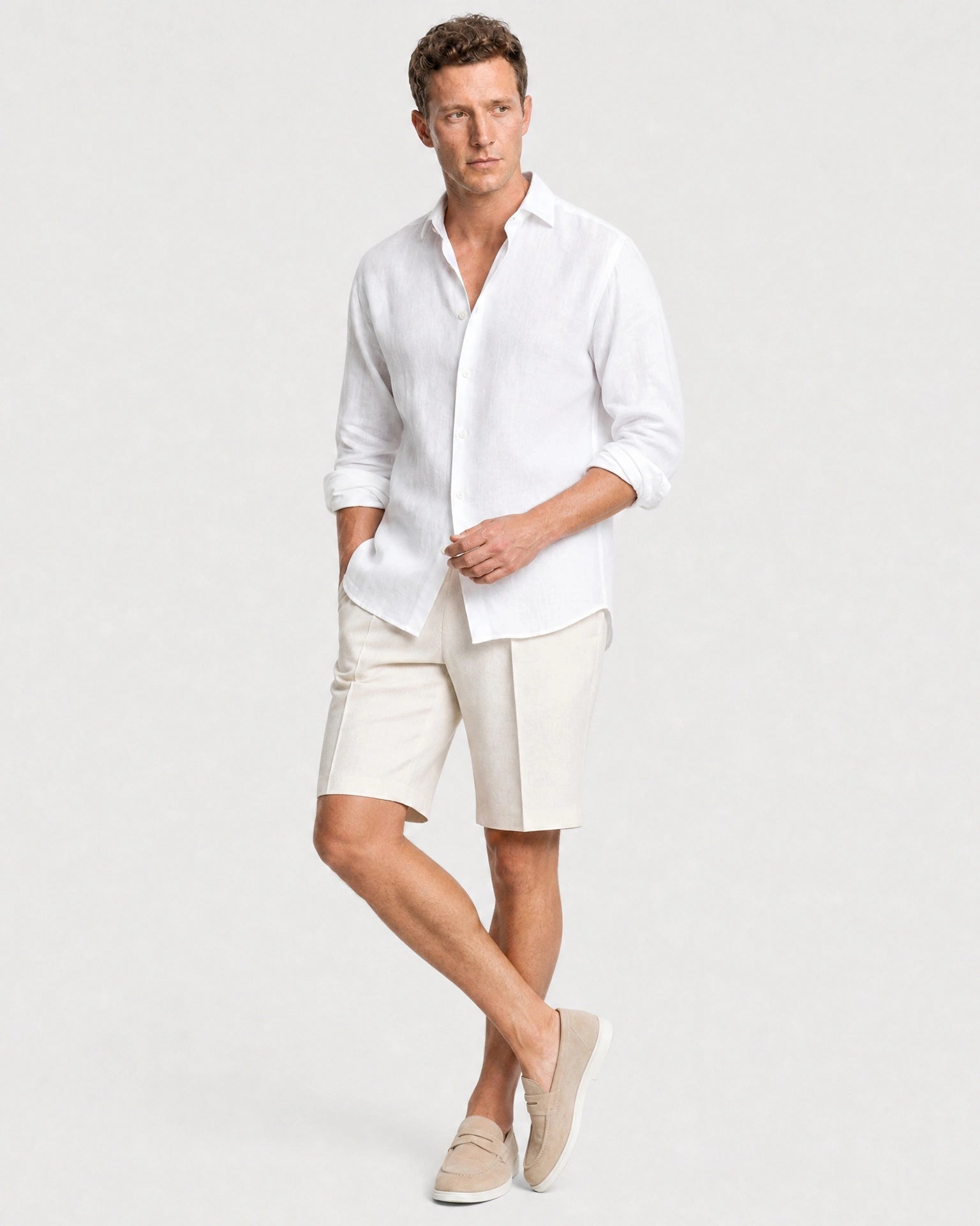 Weißes Leinen Langarmhemd Herren Ganzkörper lässige Pose, beige Leinenshorts und beige Suede-Loafer, sommerlicher Look