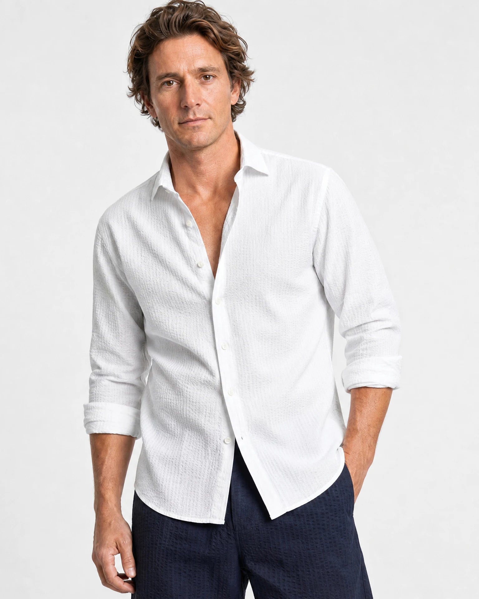 Weißes Seersucker Hemd Herren Dreiviertelansicht, offener Haifischkragen, Ärmel hochgekrempelt, navy Shorts, lässiger Sommerstil