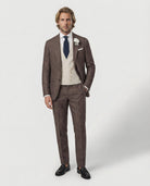 Mann im braunen Anzug mit cremefarbener Weste stehend und Hand in der Tasche