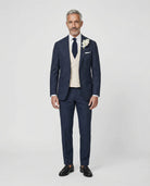 Mann im dunkelblauen Anzug mit beiger Weste von vorne fotografiert