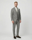 Mann im grauen Anzug mit Weste stehend seitlich fotografiert