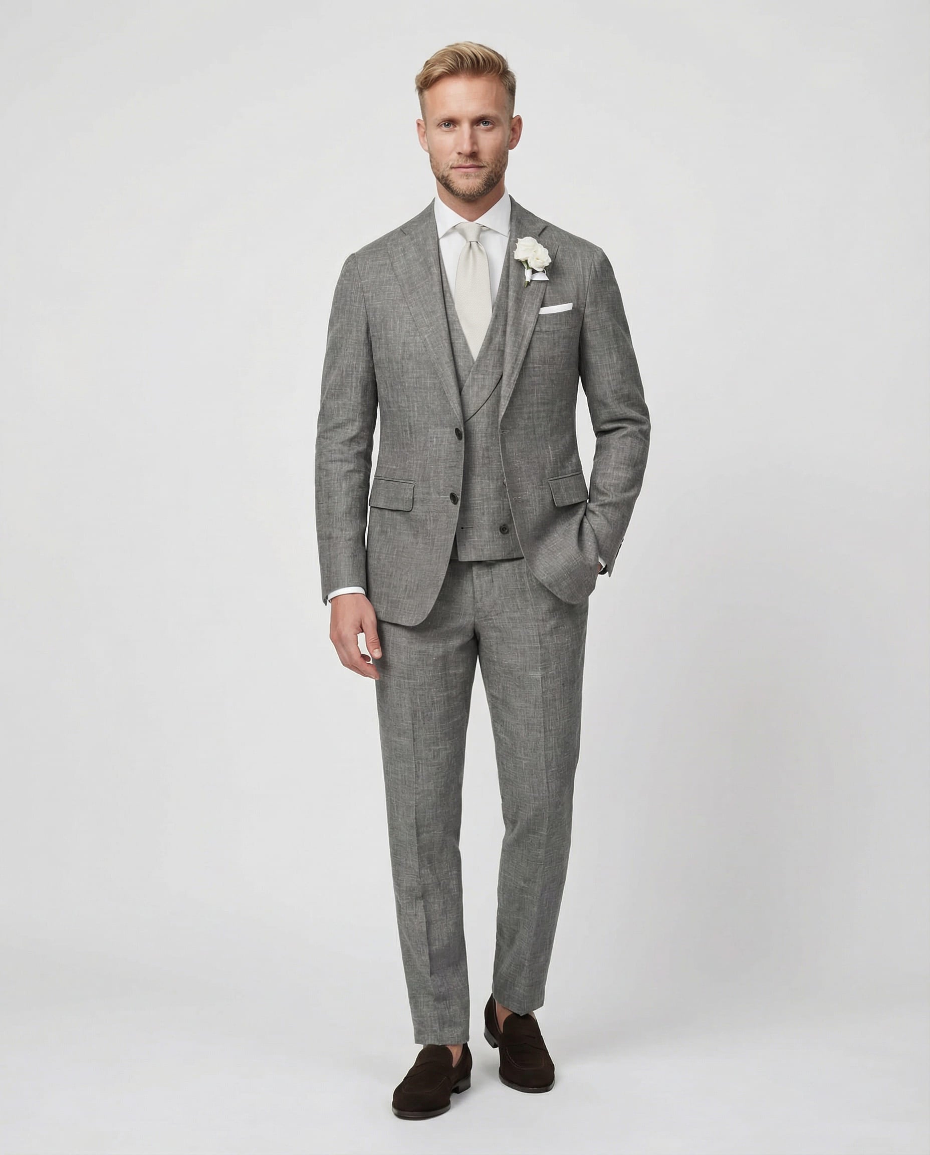 Mann im grauen Anzug mit Weste stehend mit Hand in der Tasche