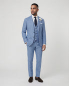 Mann im hellblauen Anzug mit Weste stehend mit der Hand in der Tasche