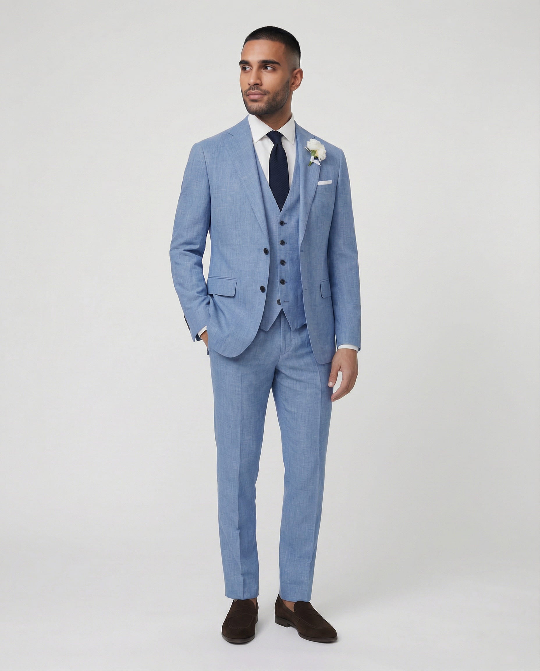 Mann im hellblauen Anzug mit Weste stehend mit der Hand in der Tasche