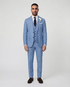 Mann im hellblauen Anzug mit Weste stehend mit offenem Sakko