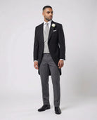 Mann im anthraziten Cutaway mit hellgrauer Weste und Stresemann Hose seitlich gezeigt mit offenem Knopf