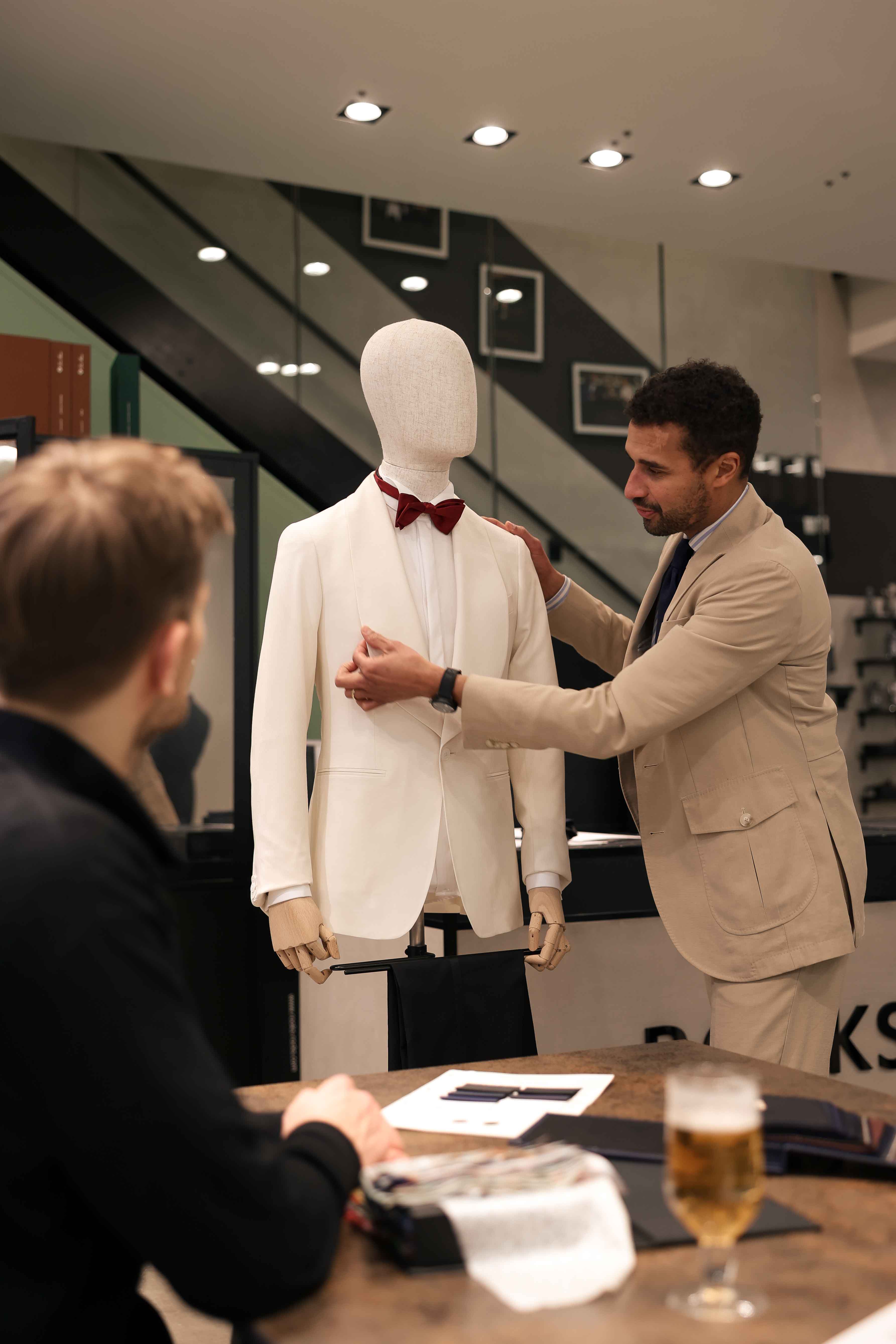 Die Details eines Hochzeitsanzuges werden mit dem Kunden besprochen