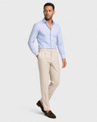 blau-weiß gestreiftes Maßhemd Herren Dreiviertelansicht in Bewegung, beige Bundfaltenhose, braune Tassel-Loafer