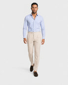 Blau-weiß gestreiftes Maßhemd Herren in Laufpose, beige Leinenbundfaltenhose und braune Tassel-Loafer