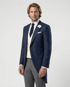 Mann im blauen Cutaway mit beiger Weste und Stresemann Hose als Nahaufnahme seitlich gezeigt