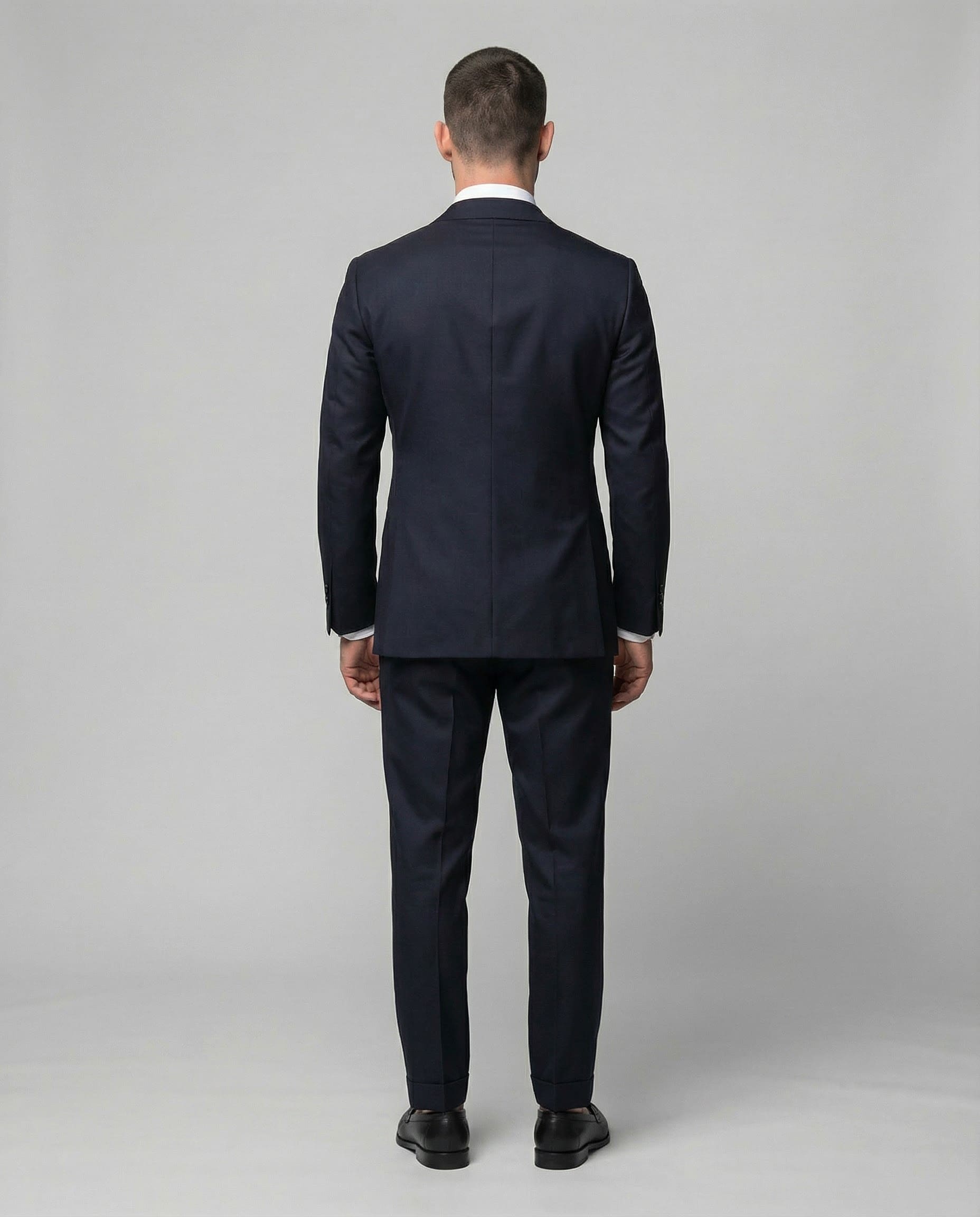 Mann im dunkelblauen Anzug aus reiner Schurwolle von hinten abgebildet