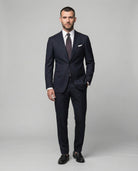 Mann im dunkelblauen Anzug aus reiner Schurwolle von vorne abgebiledet mit Hand in der Tasche