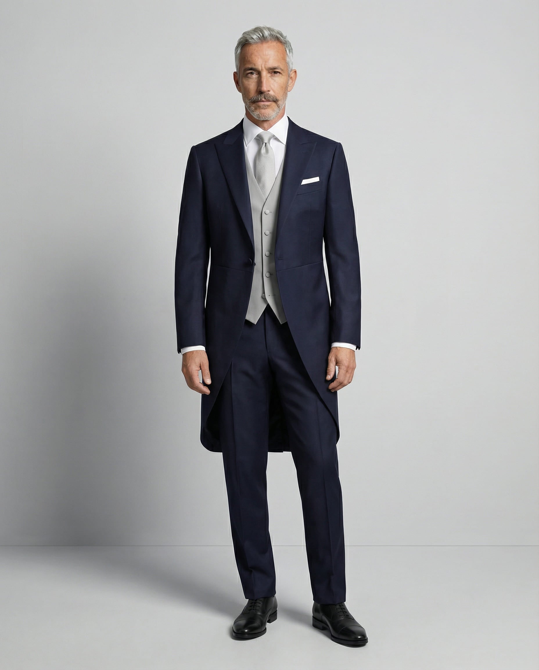 Mann im dunkelblauen Cutaway mit hellgrauer Weste von vorne gezeigt mit offenem Sakko