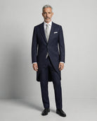 Mann im dunkelblauen Cutaway mit hellgrauer Weste von vorne gezeigt mit geschlossenem Knopf