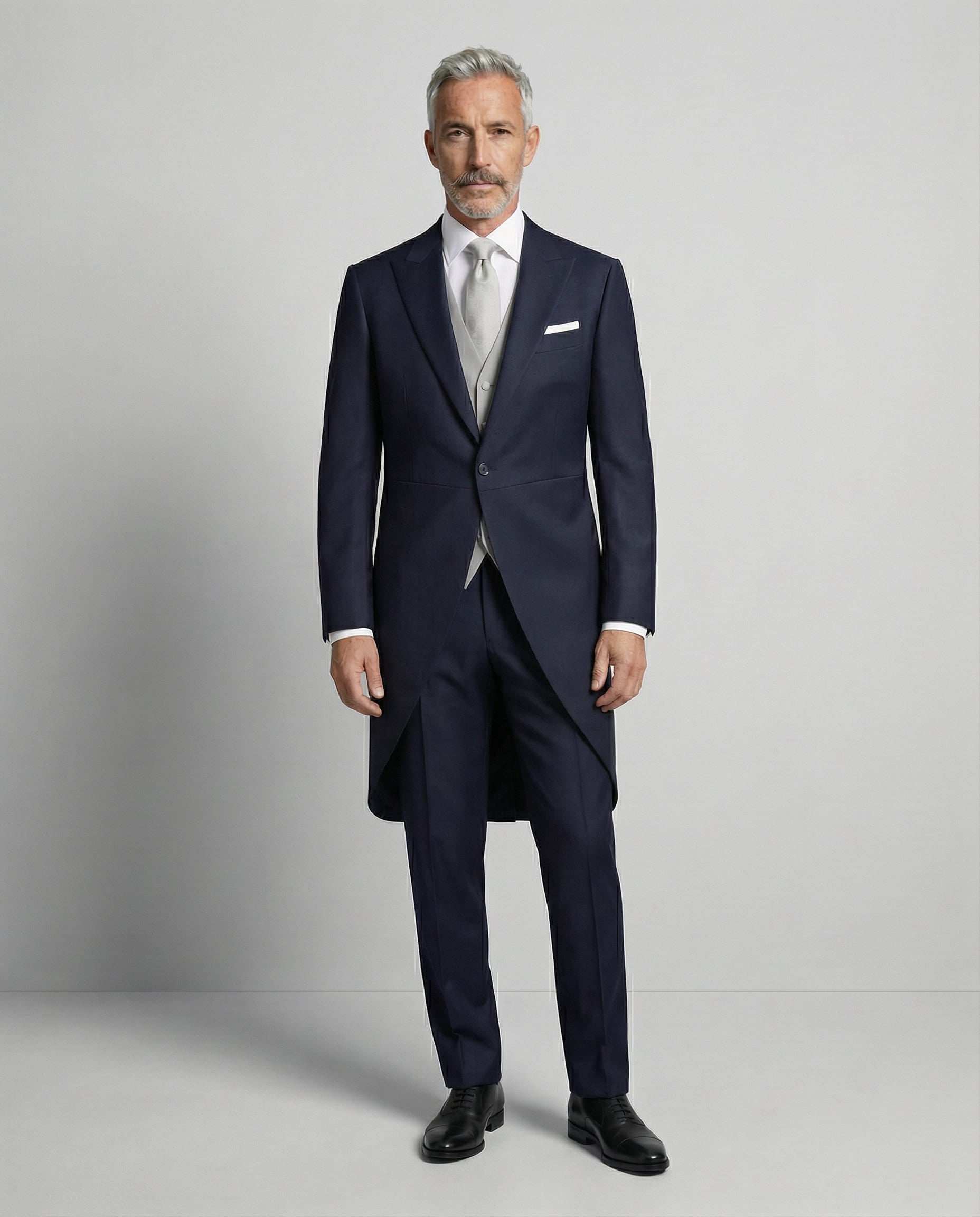 Mann im dunkelblauen Cutaway mit hellgrauer Weste von vorne gezeigt mit geschlossenem Knopf