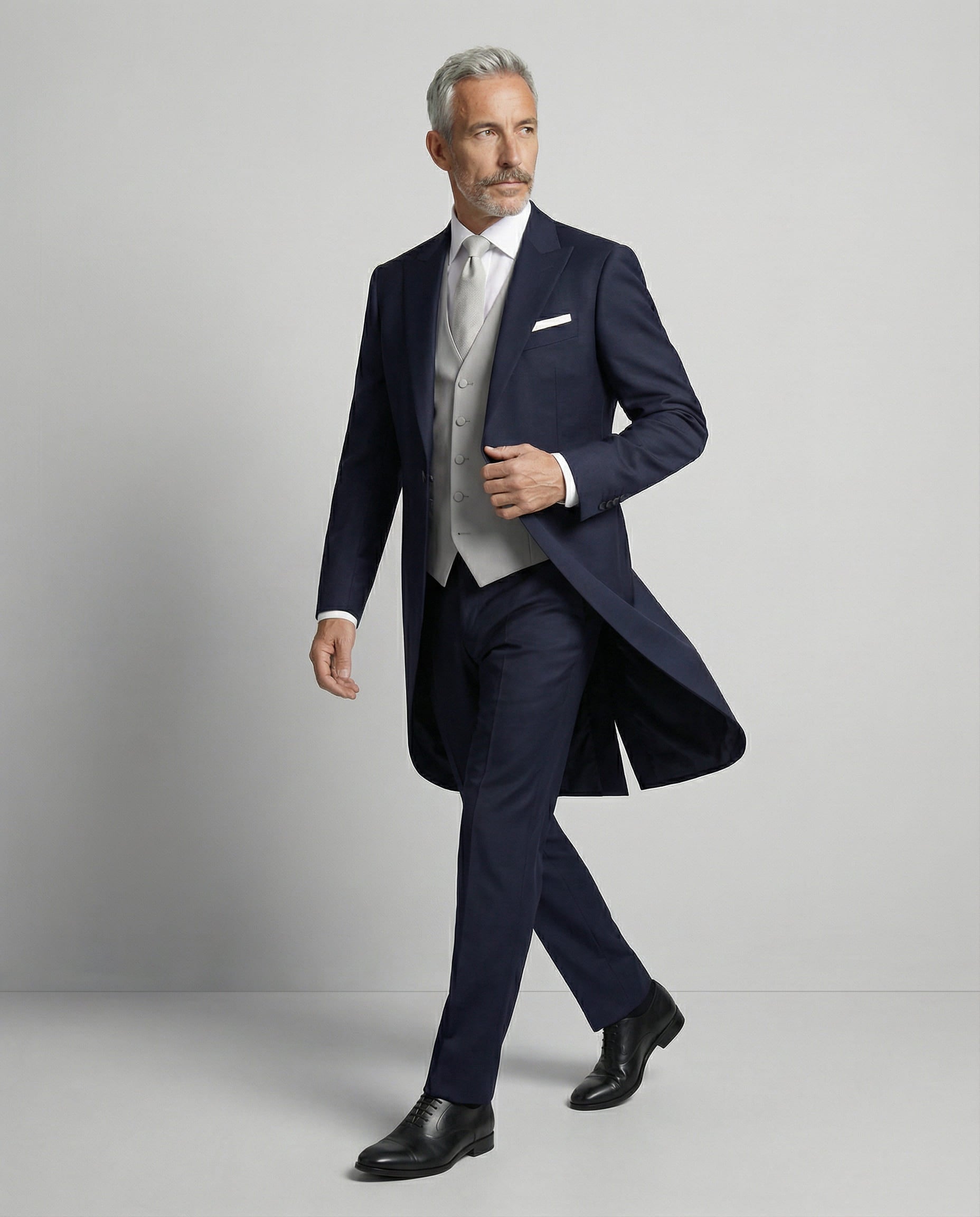 Mann im dunkelblauen Cutaway mit hellgrauer Weste in Bewegung seitlich gezeigt