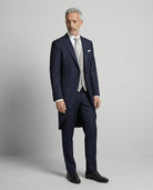 Mann im dunkelblauen Cutaway mit hellgrauer Weste seitlich gezeigt mit offenem Sakko