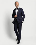 Mann im dunkelblauen Smoking mit Hand in der Tasche abgebildet