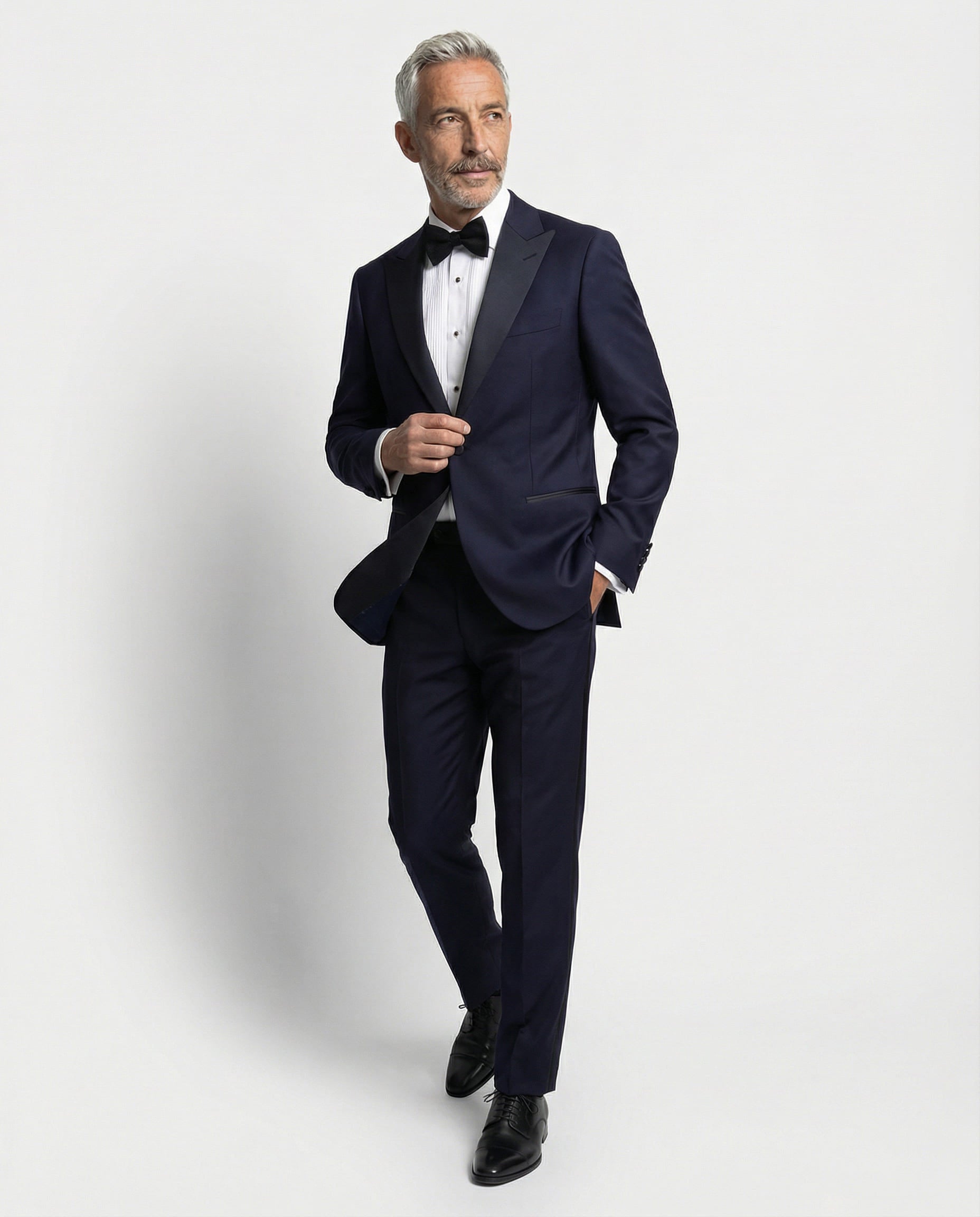Mann im dunkelblauen Smoking mit Hand in der Tasche abgebildet