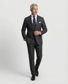 Mann im dunkelgrauen Anzug aus leicht strukturierter Schurwolle mit offener Webung in Bewegung von vorne abgebildet