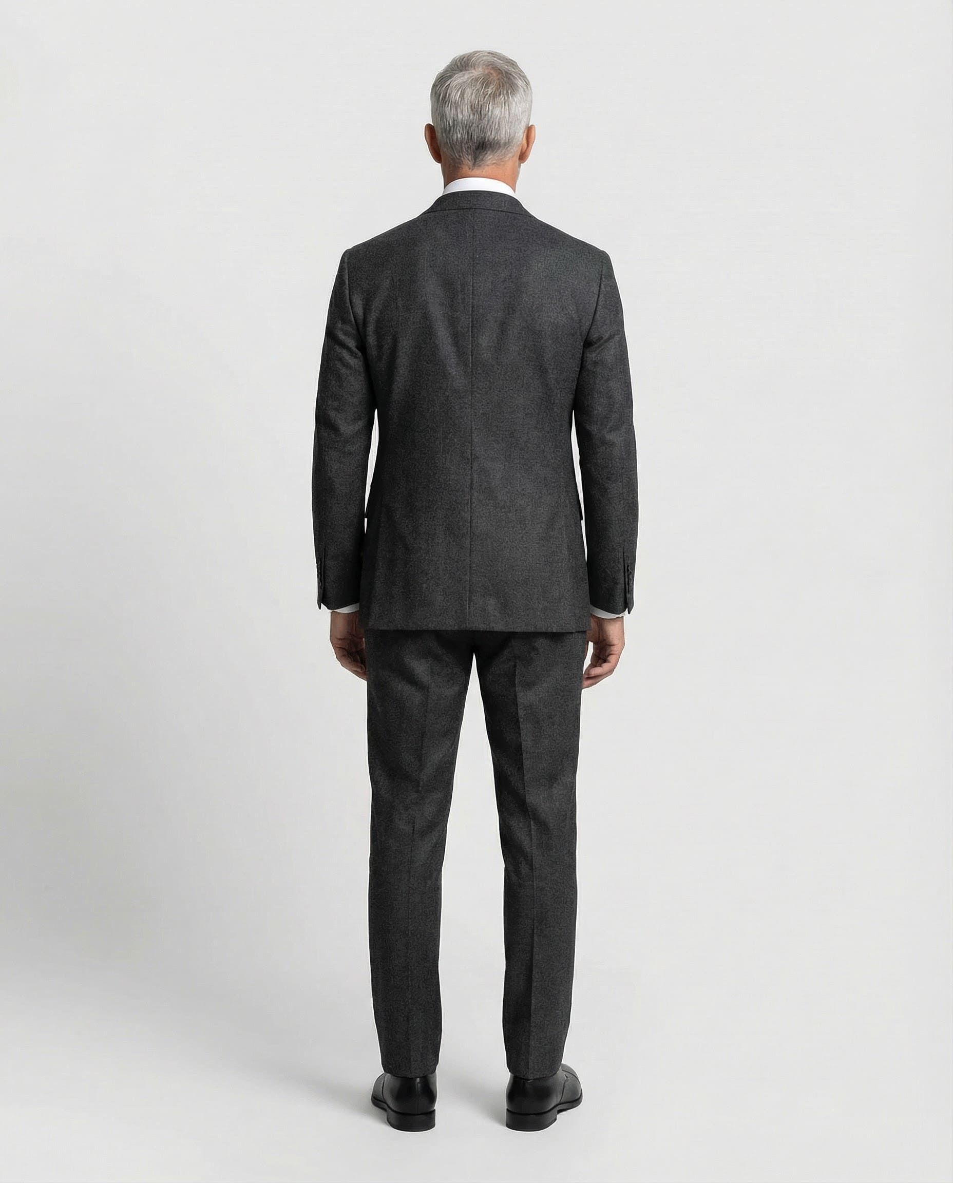 Mann im dunkelgrauen Anzug aus leicht strukturierter Schurwolle mit offener Webung von hinten abgebildet