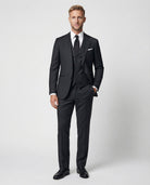 Mann im dunkelgrauen Anzug aus reiner Schurwolle mit Weste und Hand in der Tasche von vorne