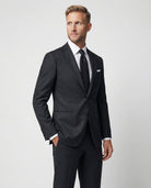 Mann im dunkelgrauen Anzug aus reiner Schurwolle Nahaufnahme mit Hand in der Tasche