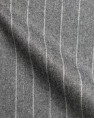 Nahaufnahme des grauen Flanellstoffs mit weißen Kreidestreifen in weichem Faltenwurf