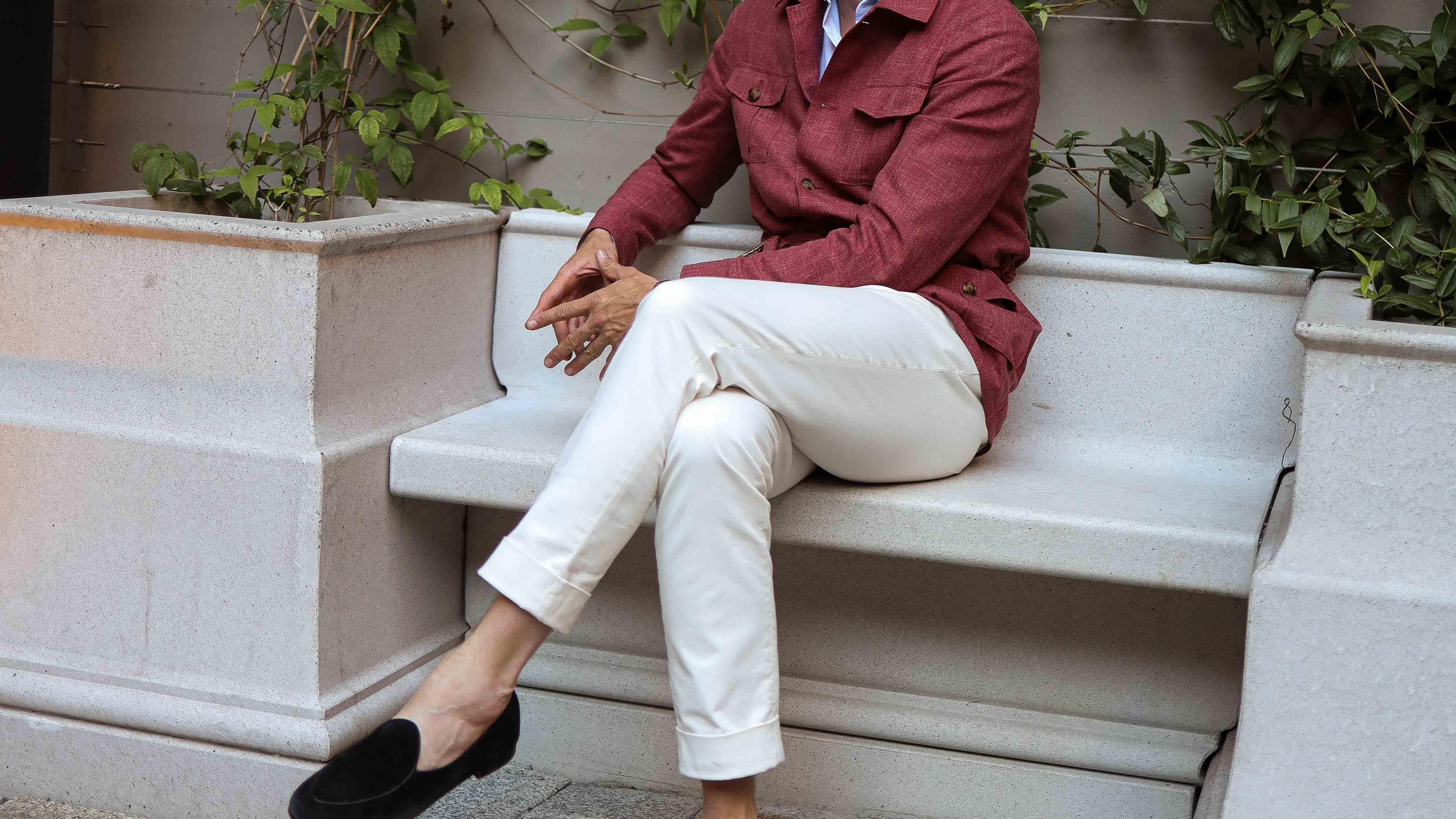 Kunde sitzt mit Chino auf Bank