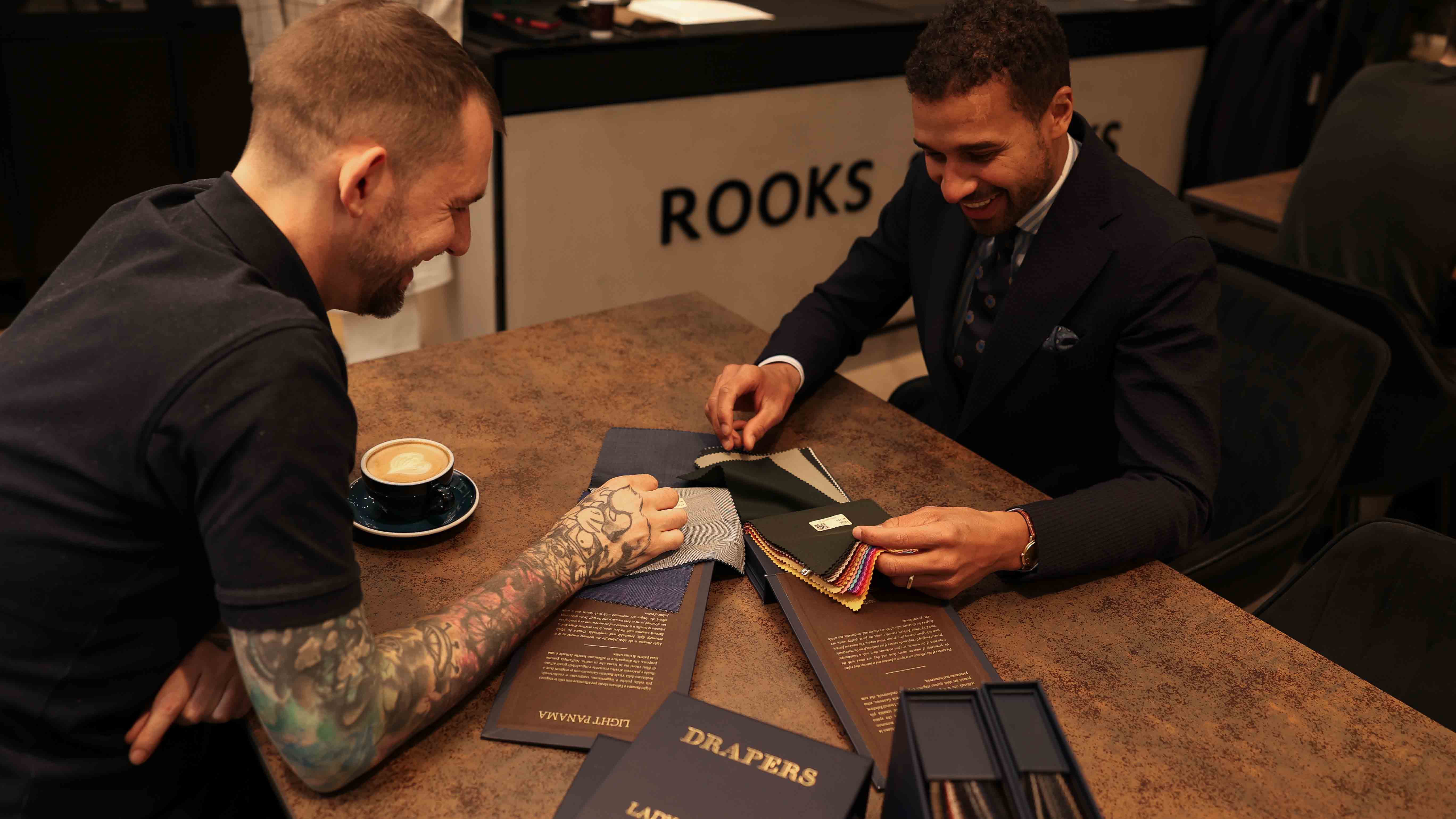 Kunde sitzt mit Berater am Tisch und bespricht sich hinsichtlich der Preisgestaltung