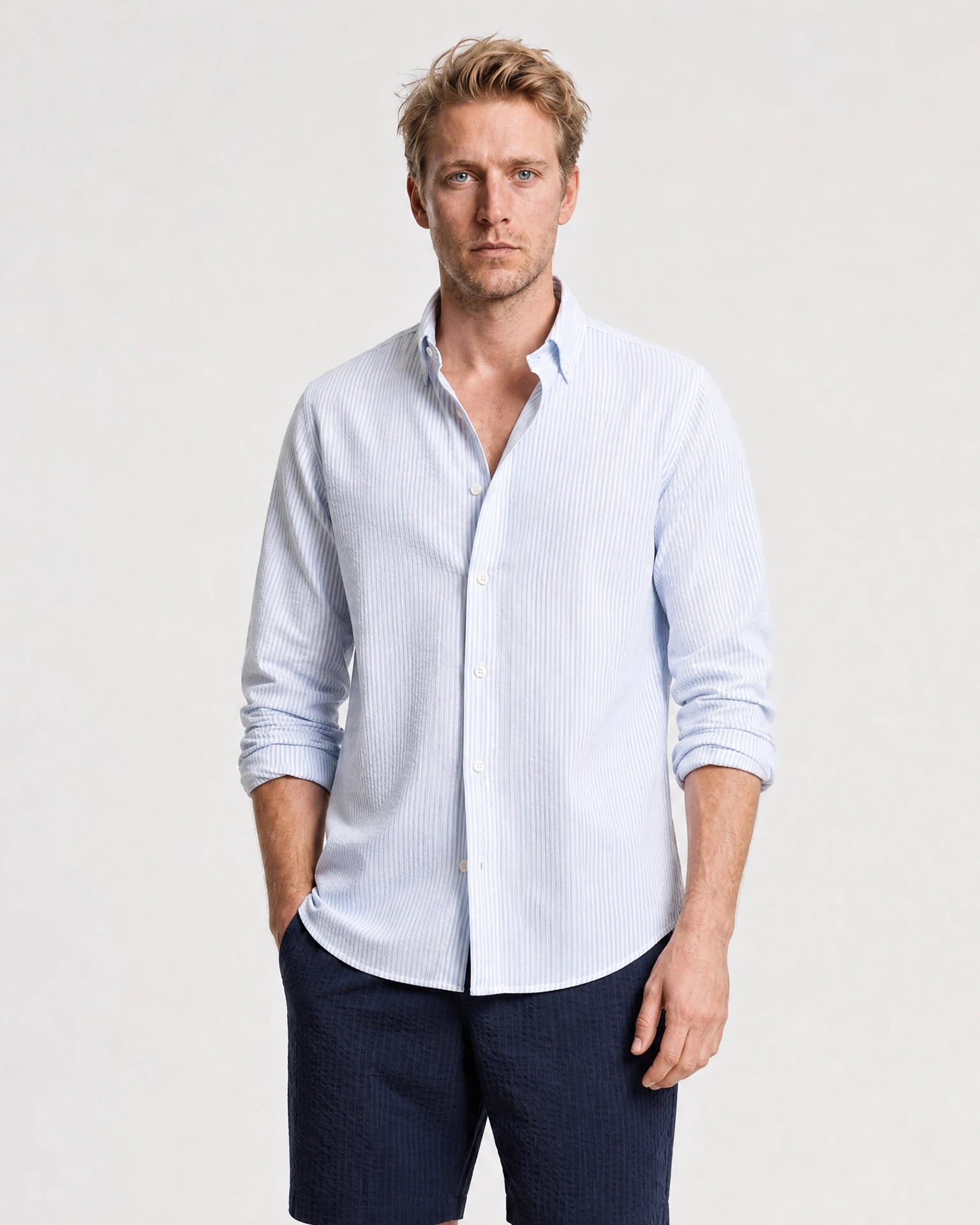 Hellblau-weiß gestreiftes Seersucker Hemd Herren Oberkörper, Button-Down-Kragen offen, Ärmel hochgekrempelt, zu navy Shorts