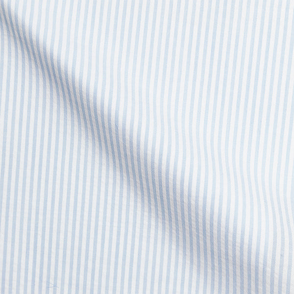 Detailaufnahme hellblau-weiß gestreifter Seersucker-Stoff, feine Streifen mit charakteristischer Kräuselstruktur, atmungsaktives Premium-Baumwollmaterial