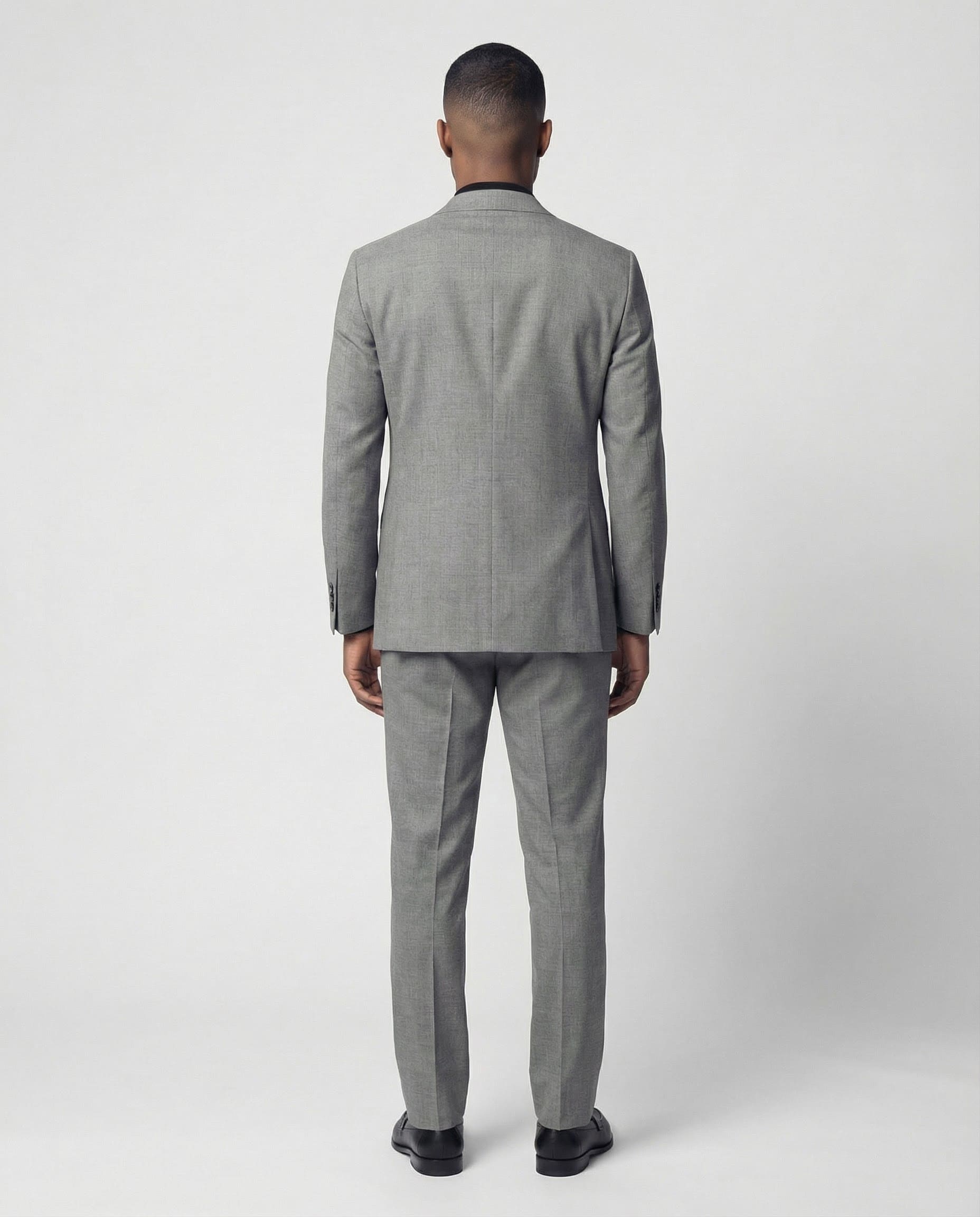 Mann im hellgrauen Anzug aus leicht strukturierter Schurwolle mit offener Webung von hinten abgebildet