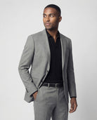 Mann im hellgrauen Anzug aus leicht strukturierter Schurwolle mit offener Webung Nahaufnahme mit Hand in der Tasche