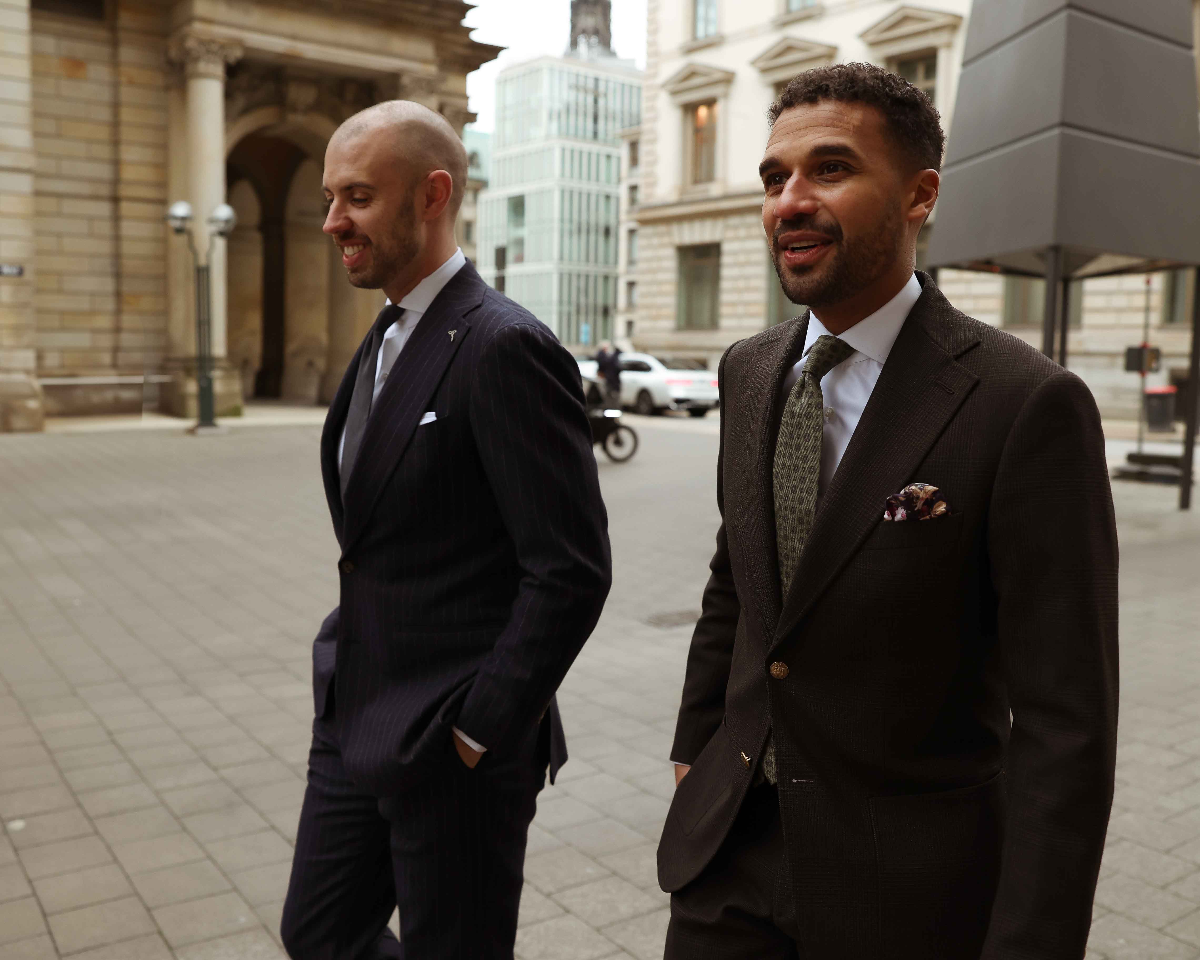 Simon und Rico tragen Business Anzüge und laufen durch Hamburg