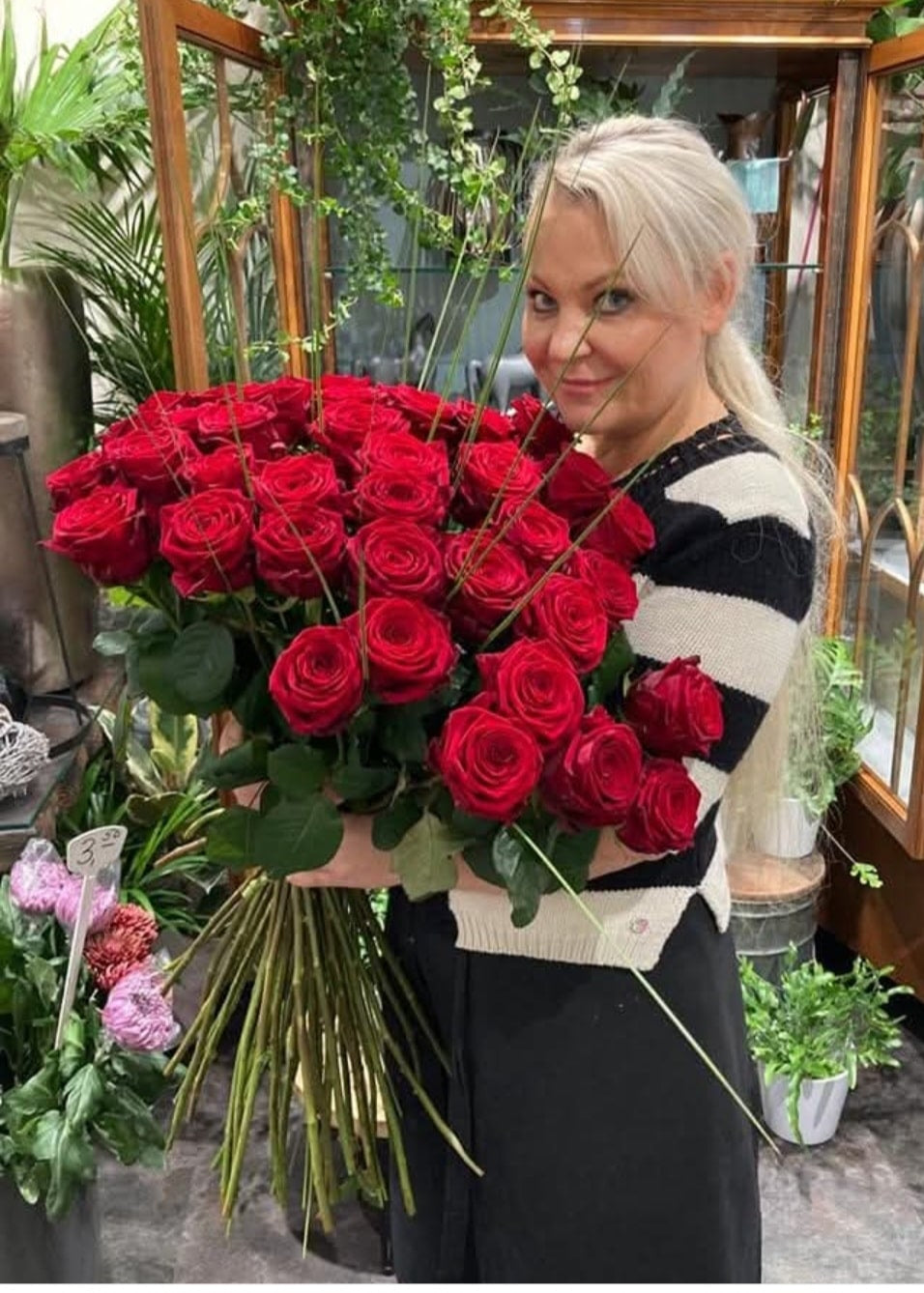 Eine Frau hält einen Strauß Rosen in den Händen