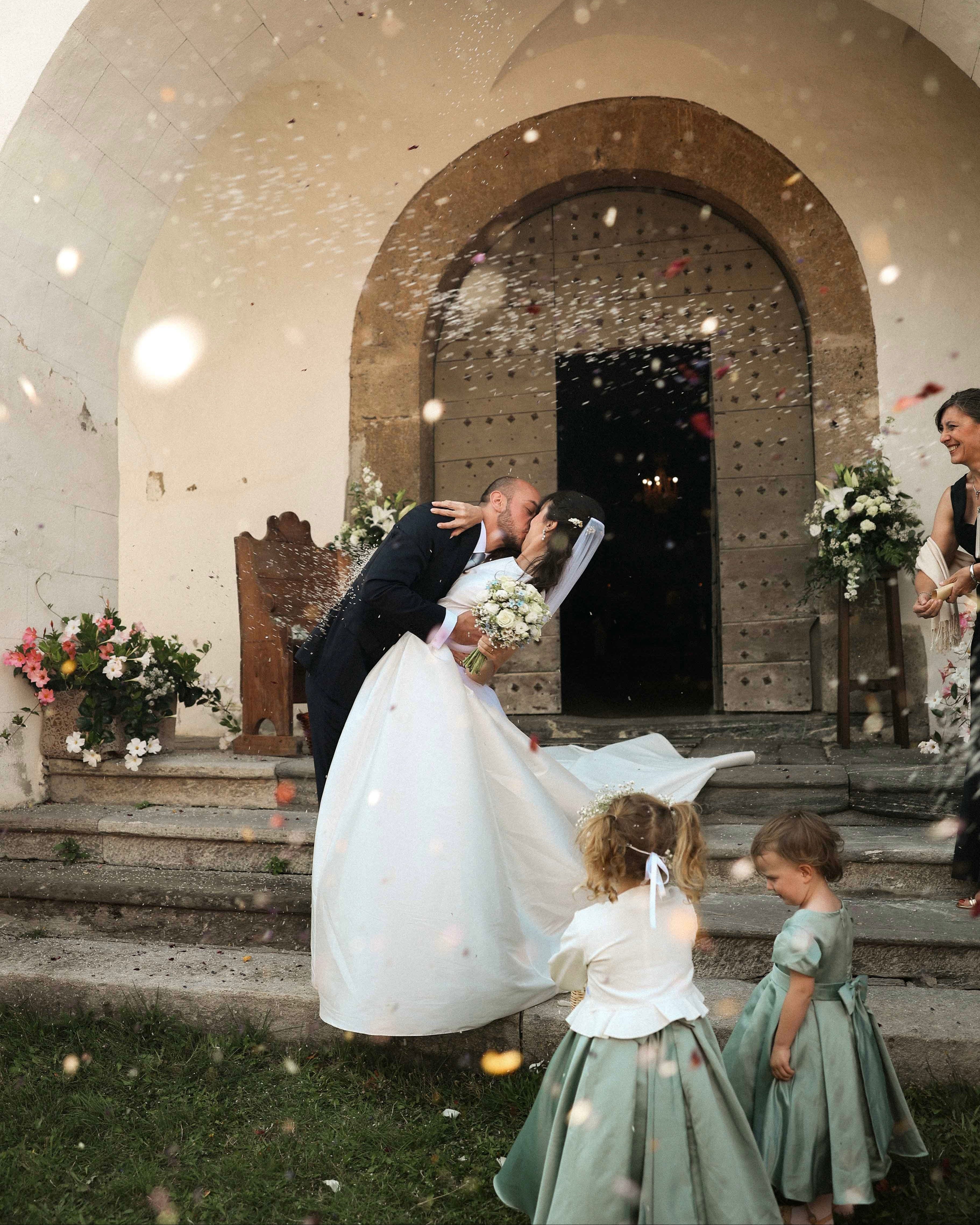 Braut und Bräutigam verlassen die Kirche und küssen sich