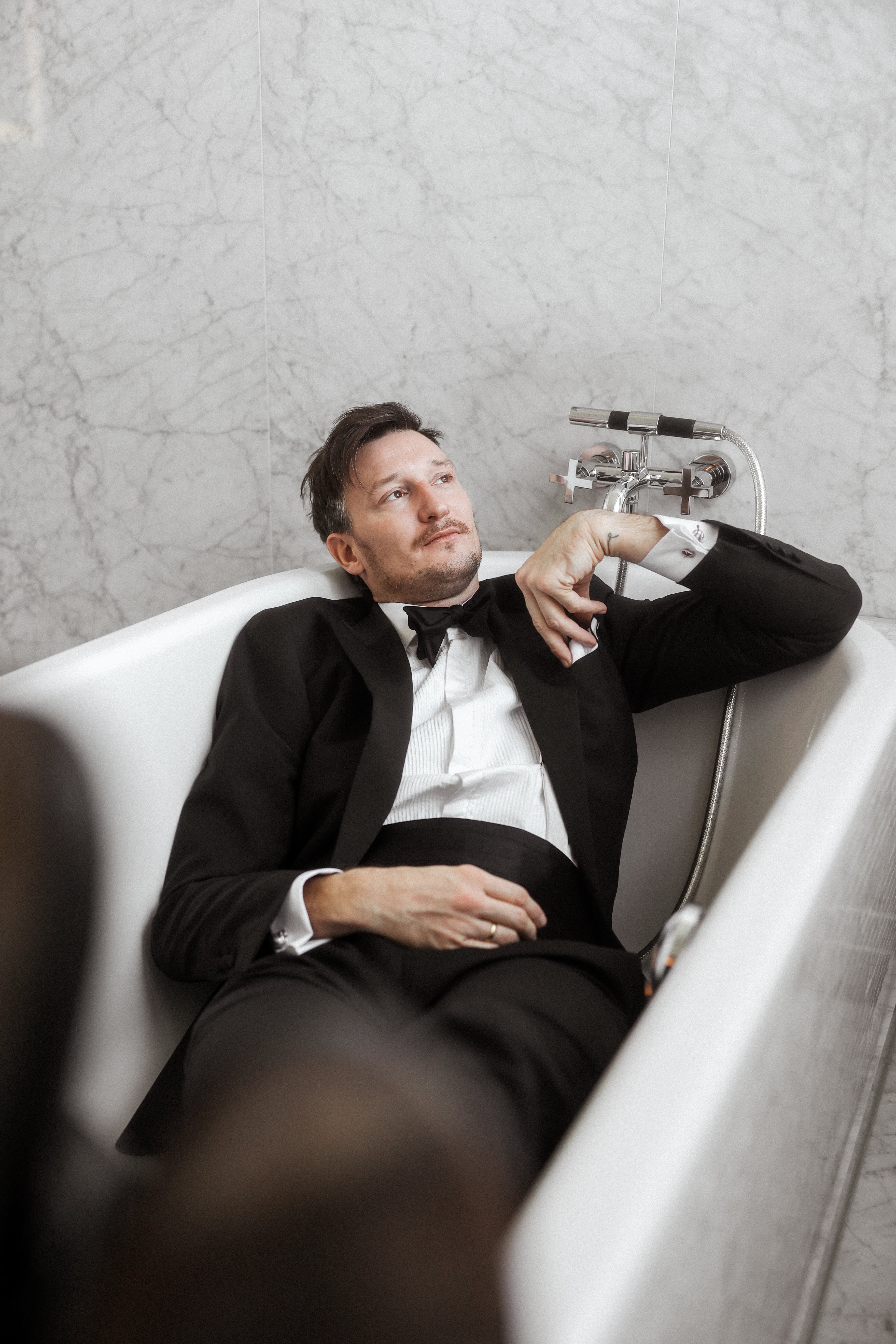 Viktor liegt im Smoking in der Badewanne