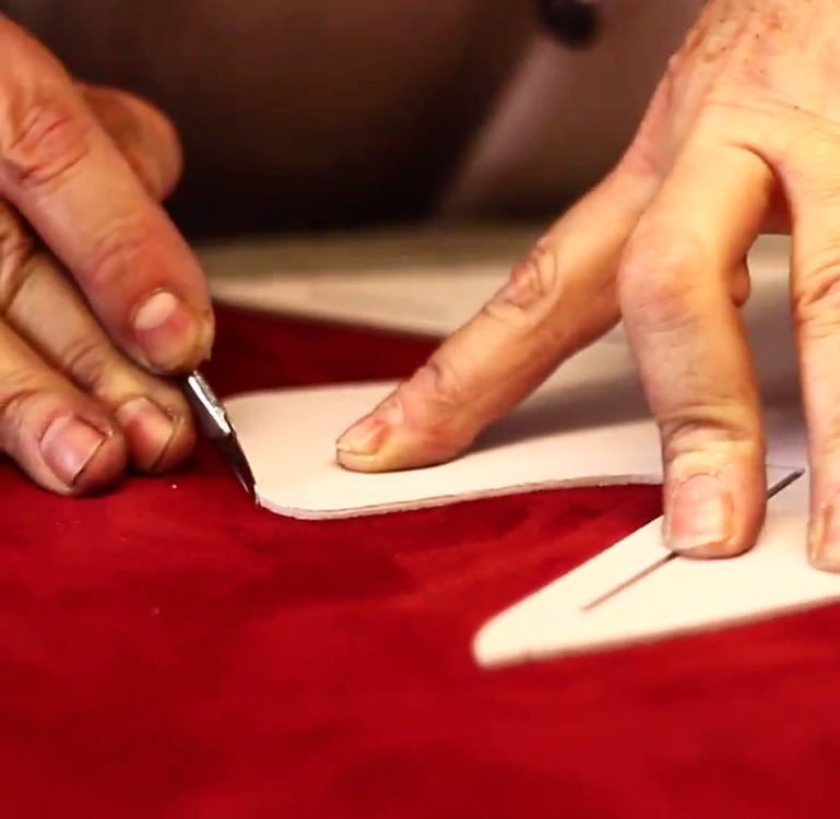 Das Leder für Schuhe wird von Hand zugeschnitten