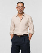 Sand-beiges Leinen Herringbone Hemd Herren Oberkörper, offener Haifischkragen, Ärmel hochgekrempelt, zu navy Bundfaltenshorts