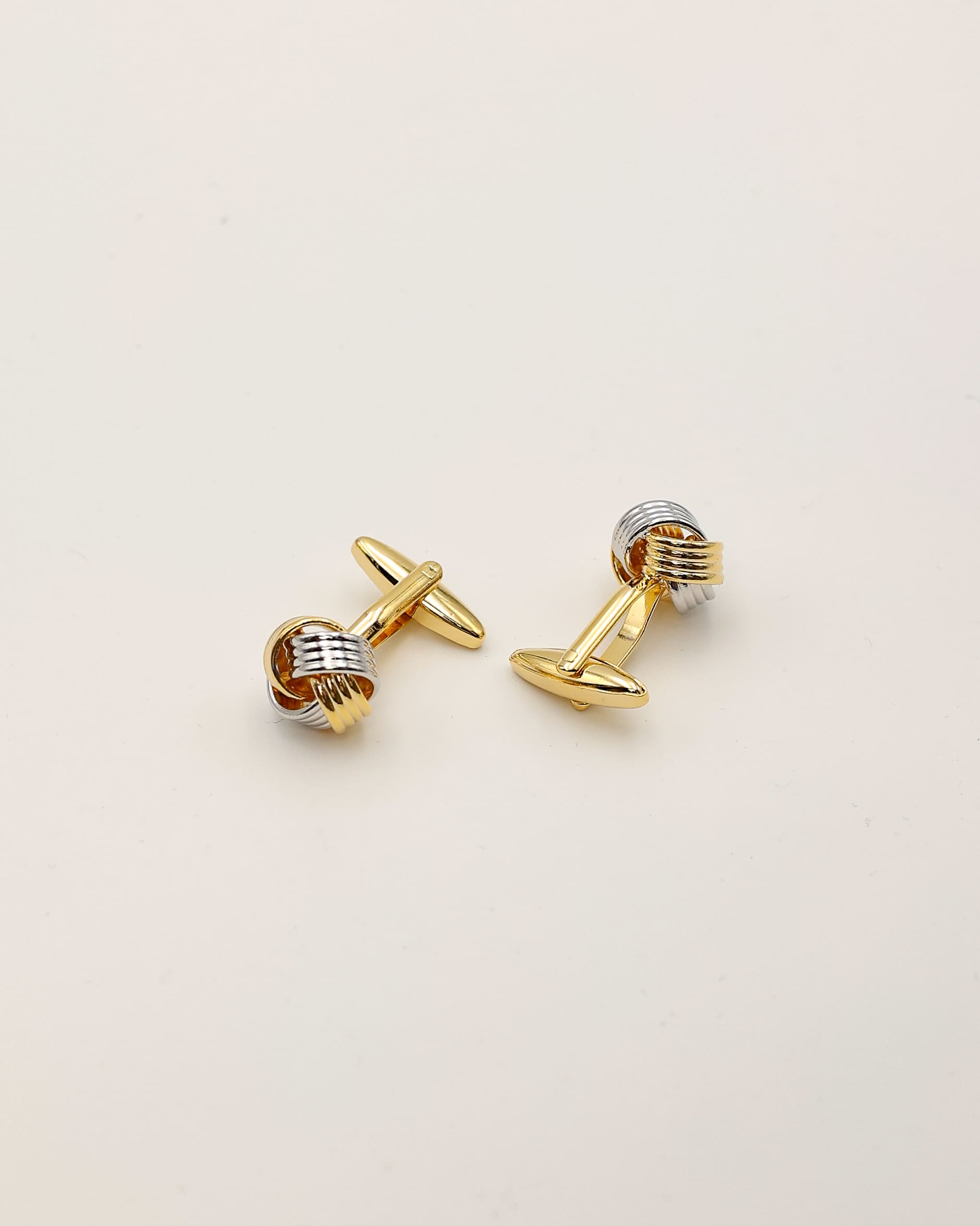 Manschettenknöpfe in gold und silber als Set liegend